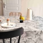 Nappe coton enduit Casopiea Gris – motif feuillage tropical blanc sur fond gris chiné