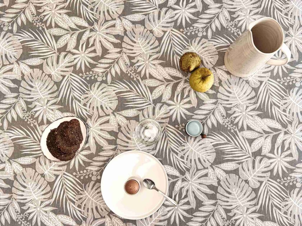 Nappe coton enduit Casopiea Gris – motif feuillage tropical blanc sur fond gris chiné