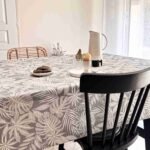 Nappe coton enduit Casopiea Gris – motif feuillage tropical blanc sur fond gris chiné