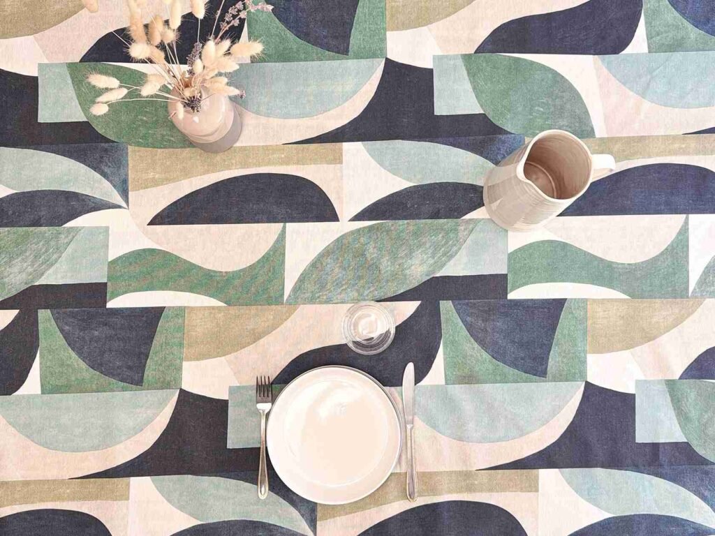 Nappe coton enduit Terax Green – motif abstrait géométrique vert sauge, bleu et beige sur fond ivoire