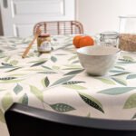 Toile cirée Class Amande – motif feuillage stylisé vert amande et sauge sur fond écru, largeur 140 cm