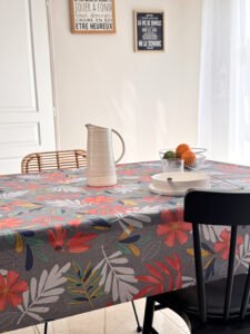Toile cirée florale Emma Bleu – fleurs rouge corail et feuillages multicolores sur fond gris bleuté, largeur 140 cm