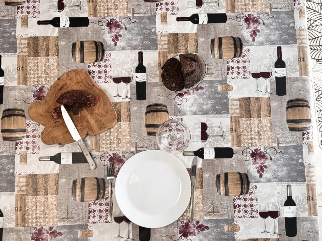  Toile cirée Taberne – motif cave à vin, fûts de chêne, bouteilles et tons beige bordeaux, largeur 140 cm