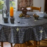 Toile cirée Louvre Anthracite 160 cm – motif géométrique 3D fond anthracite et lignes dorées, imperméable, vendue au mètre ou sur mesure toutes formes