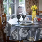 Toile cirée Nasseau Or 160 cm – motif cercles graphiques et feuilles tropicales stylisées en doré mat gris anthracite et blanc cassé, imperméable, vendue au mètre ou sur mesure toutes formes