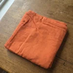 Serviette coton paprika dressée sur table – ambiance chaleureuse terracotta