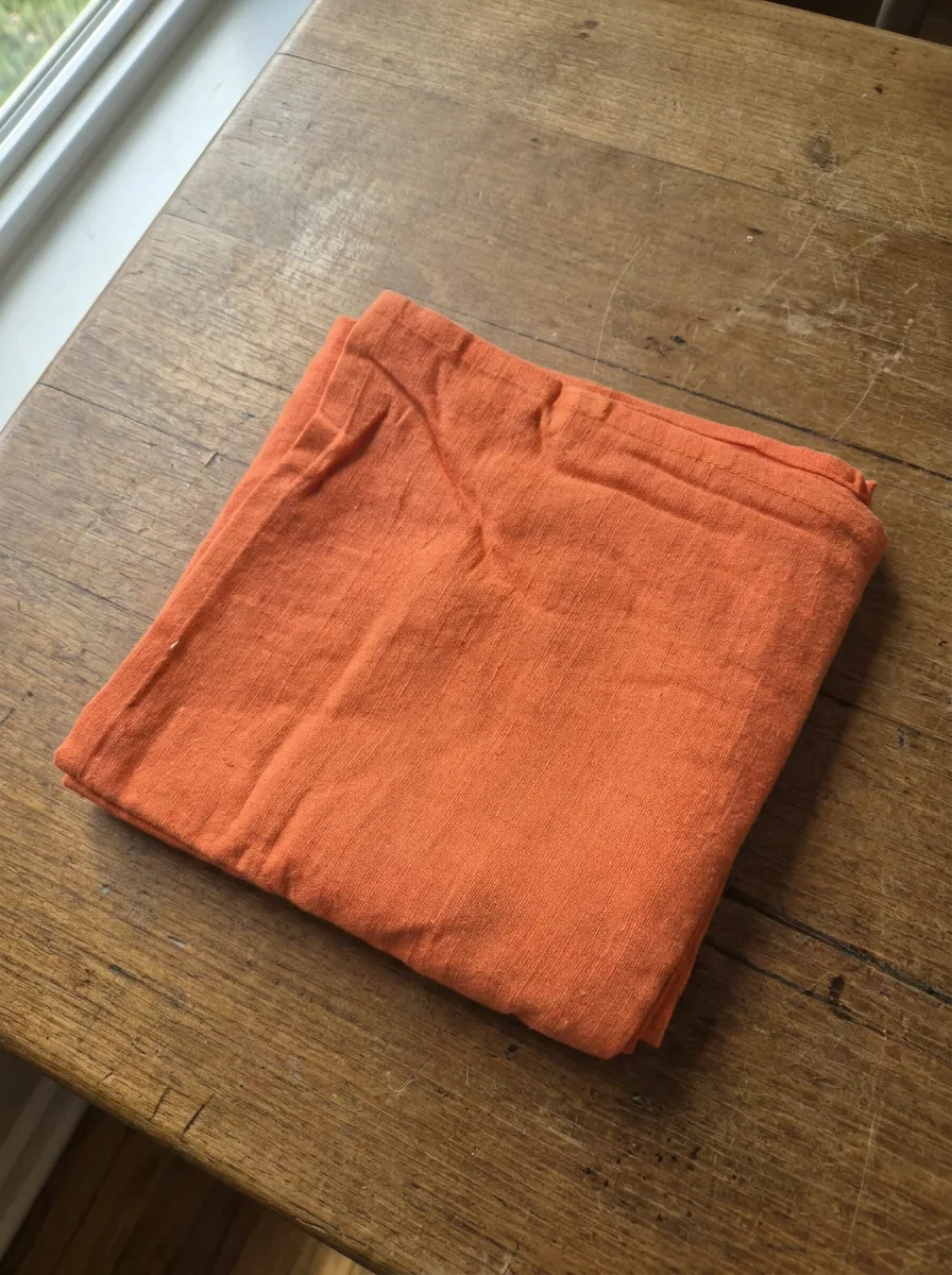 Serviette coton paprika dressée sur table – ambiance chaleureuse terracotta
