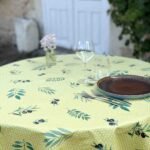 Toile cirée Ampus Vert ronde 160 cm – motif provençal branches d'olivier et olives noires sur fond vert tendre, imperméable et facile d'entretien