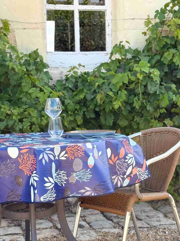Toile cirée Polynésie Bleu ronde 160 cm – motif marin poissons coraux et feuillages sur fond bleu profond, finition biais renforcé