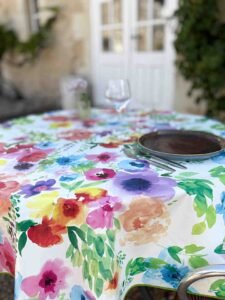 Toile cirée Printemps ronde 160 cm – imprimé floral multicolore façon aquarelle sur fond clair, finition biais renforcé`