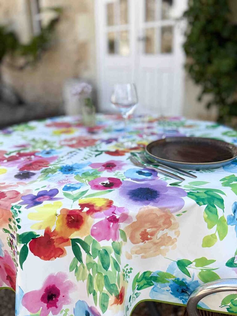 Toile cirée Printemps ronde 160 cm – imprimé floral multicolore façon aquarelle sur fond clair, finition biais renforcé`