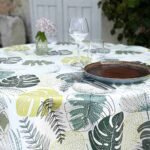 Toile cirée Tadao ronde 160 cm – motif feuillage tropical vert et jaune sur fond blanc, finition biais renforcé