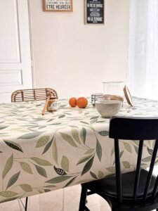 Toile cirée Class Amande – motif feuillage stylisé vert amande et sauge sur fond écru, largeur 140 cm