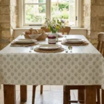 Toile cirée déco Fayence vert kaki 140 cm – motif médaillon délicat en vert kaki sur fond écru, vendue au mètre ou sur mesure