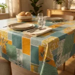 Toile cirée déco Print 140 cm – patchwork botanique en bleu céladon, orange terracotta et jaune soleil, vendue au mètre ou sur mesure