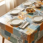 Toile cirée déco Print 140 cm – patchwork botanique en bleu céladon, orange terracotta et jaune soleil, vendue au mètre ou sur mesure
