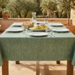 Toile cirée déco Uni façon tissu vert 140 cm – texture façon lin vert sauge aux reflets céladon, vendue au mètre ou sur mesure