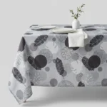 Nappe polyester tropicale Illana coloris gris – plumes et feuilles de monstera